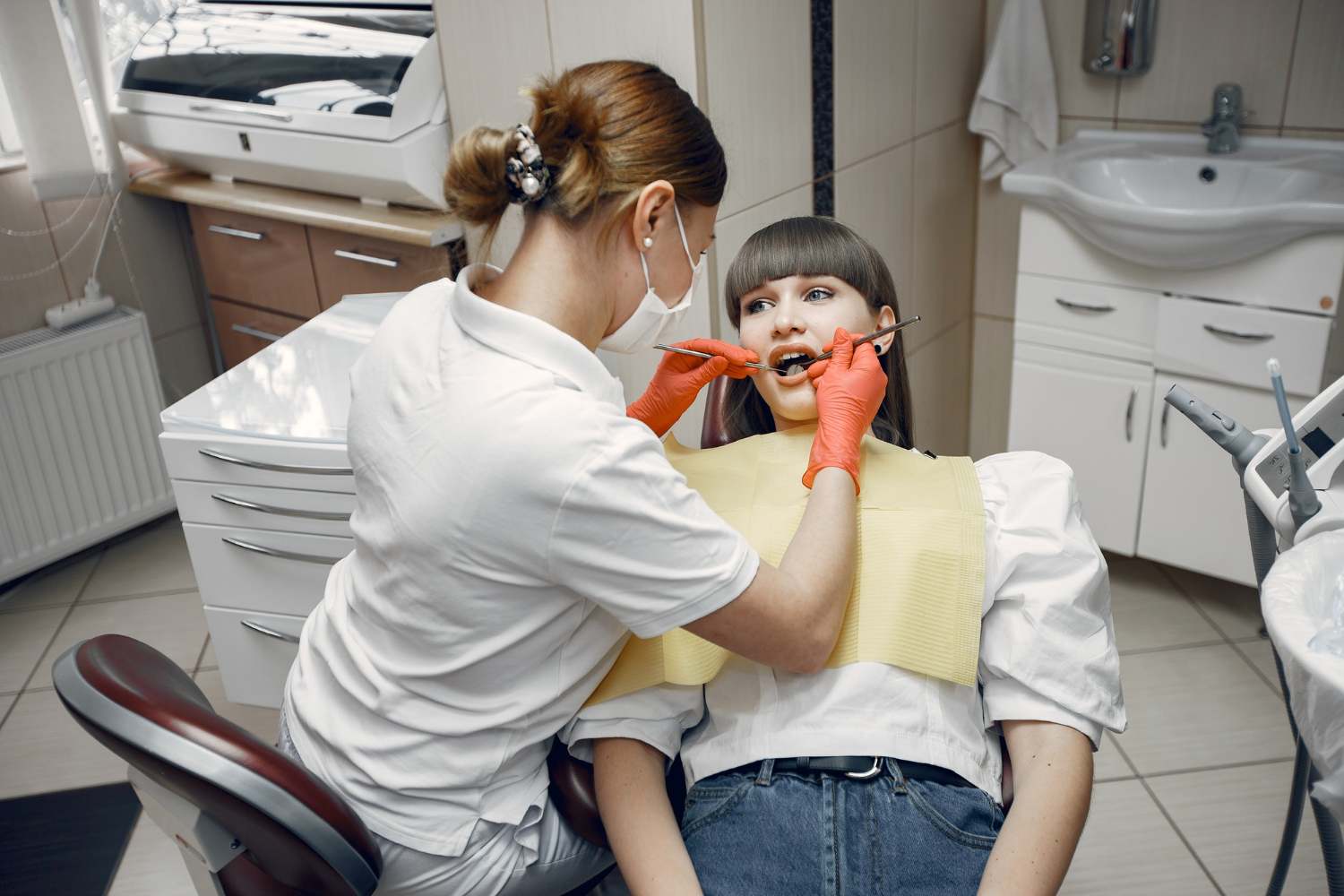 Woman in a dental chair. Girl is examined by a dentist. Beauty treats her teeth