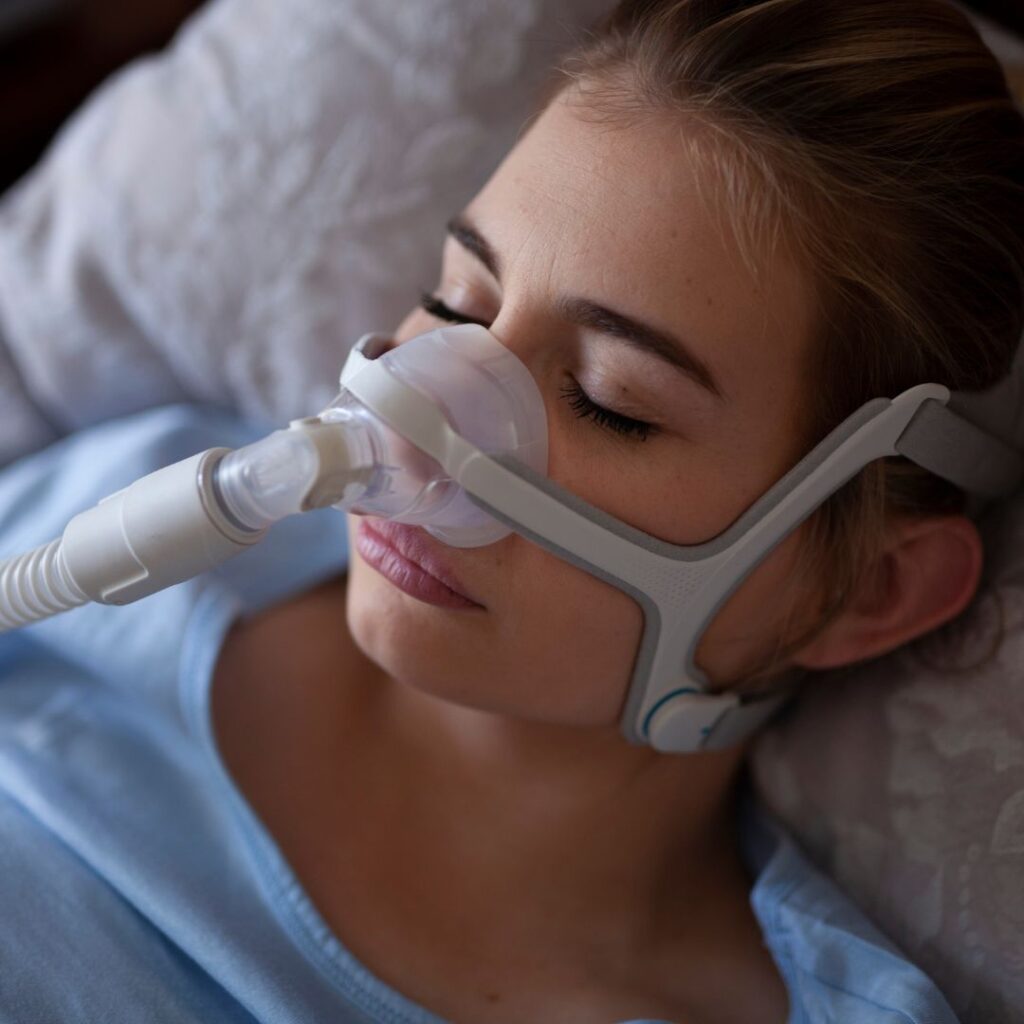 Women sleeping with some device on face suffering from Obstructive sleep apnea