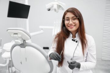 Dentist keeping dental tools and smiling in clinic